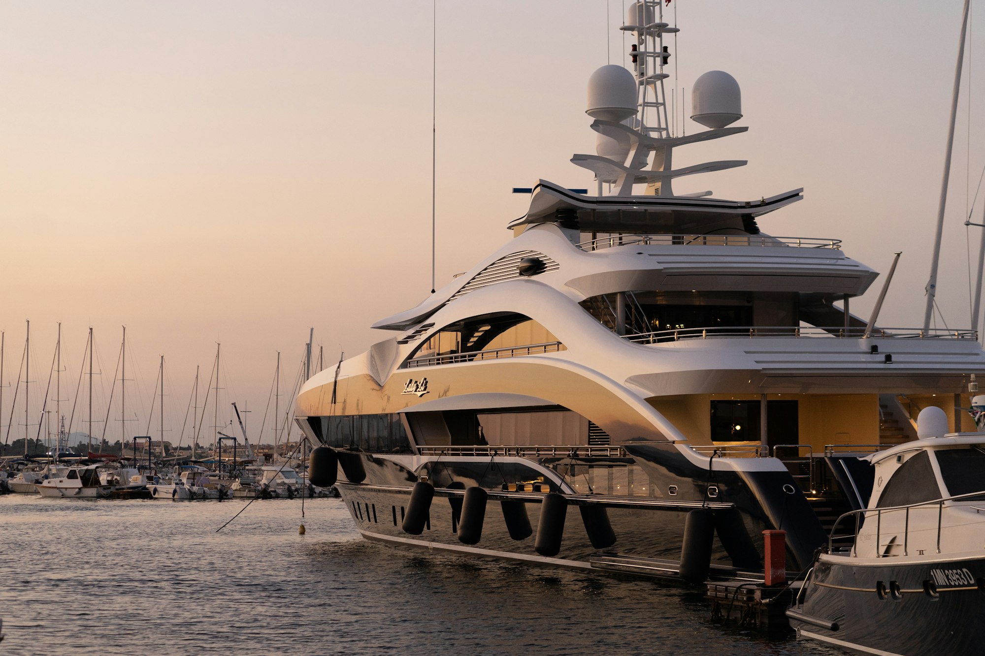 Superyacht moored in a marina at dusk
